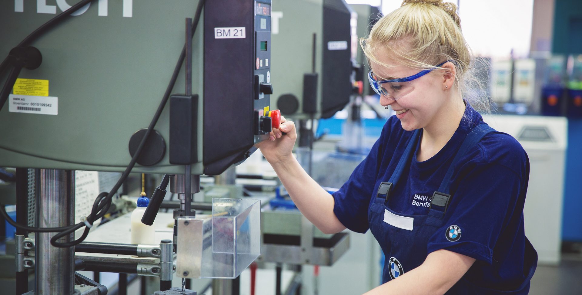 Apprentice mechatronics technician at the BMW Group operating a machine.