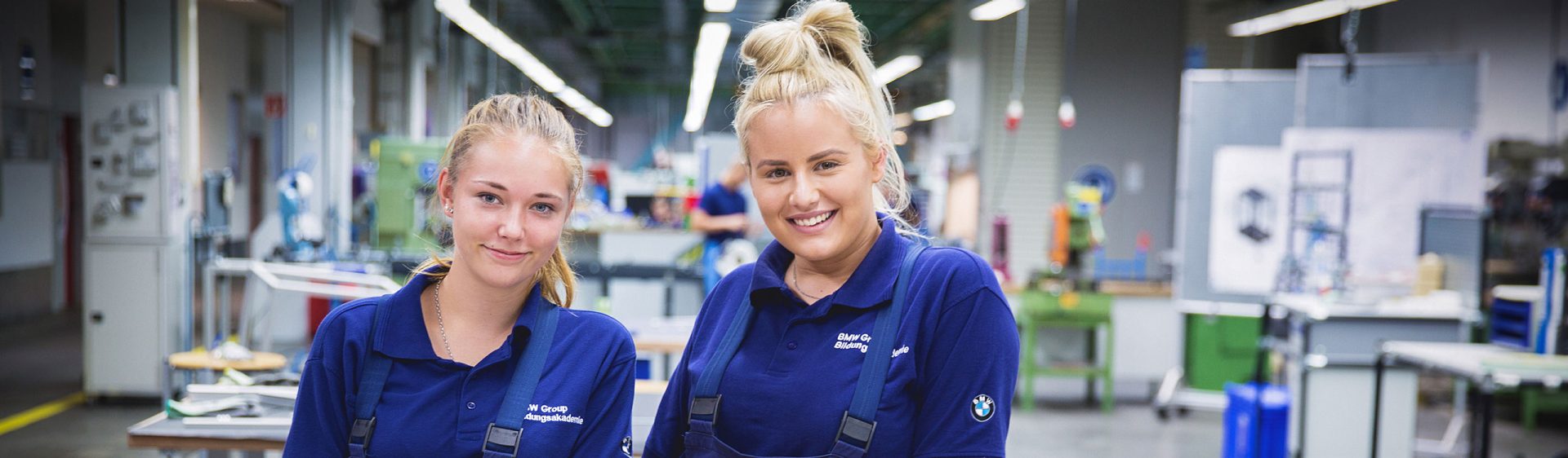 The picture shows two laughing young women during their apprenticeship at BMW.