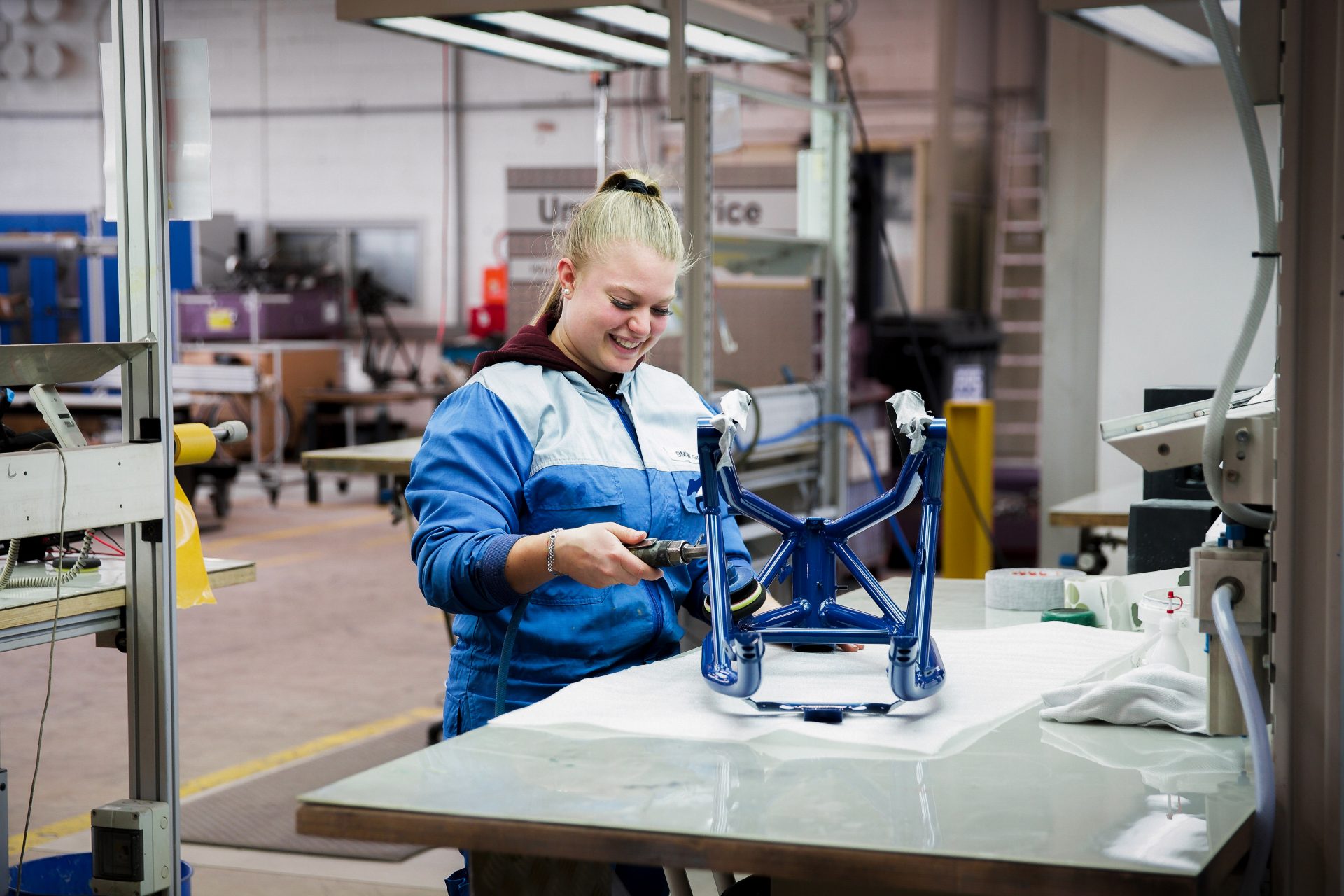 An apprentice process engineer for painting technology at the BMW Group during the painting process of a motorcycle part