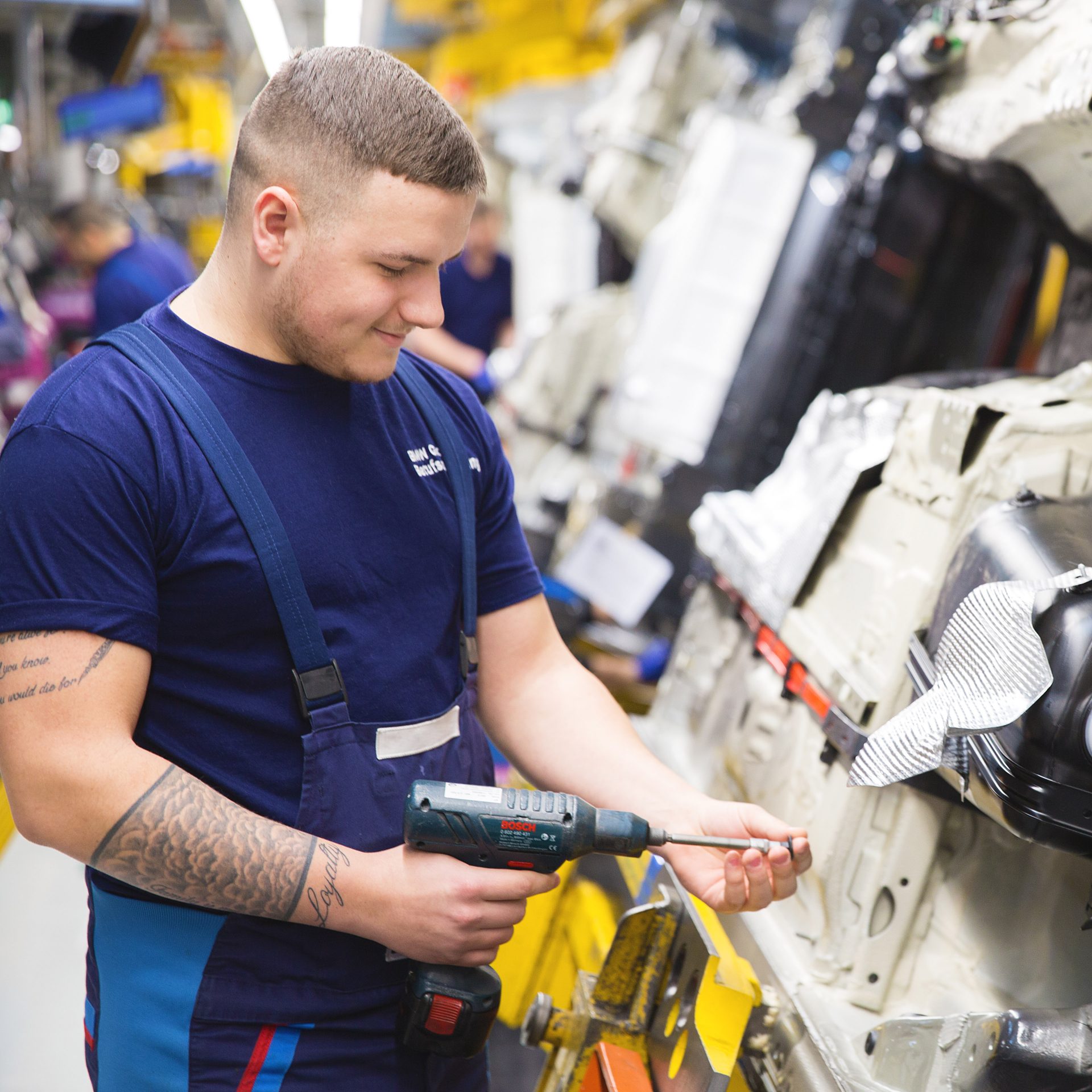 The picture shows a young production mechanics apprentice at BMW.
