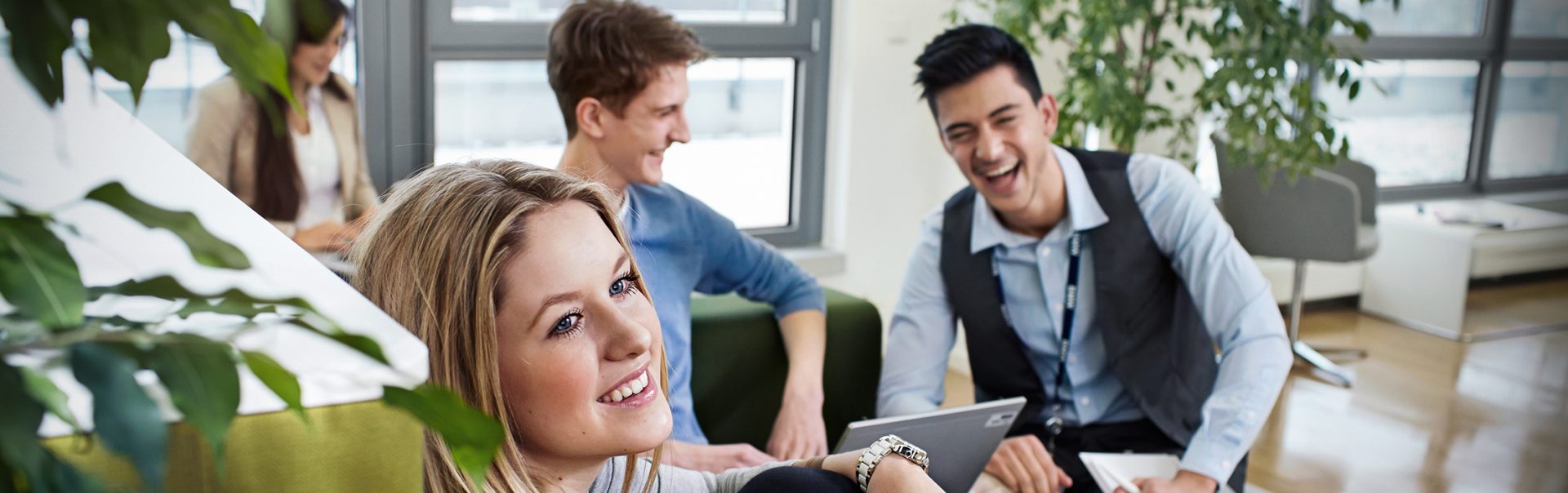Smiling trainees as social security clerks at the BMW Group in a friendly working environment.
