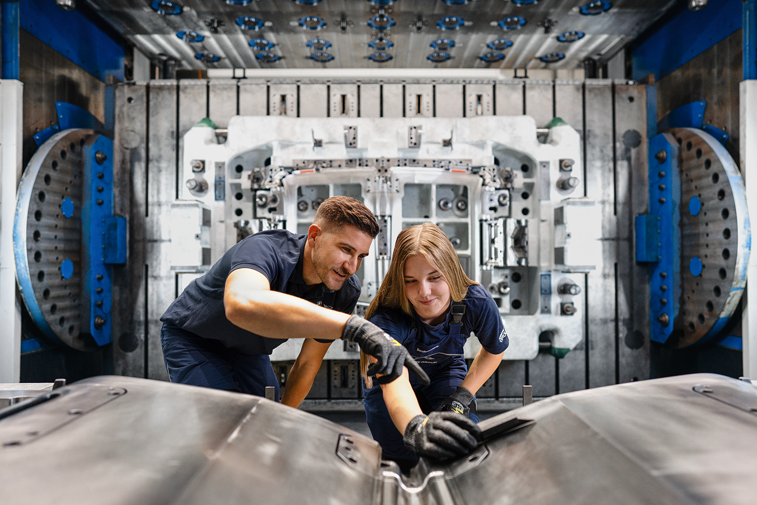 A female trainee and her trainer work on a tool system.