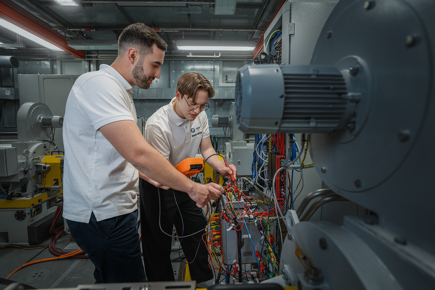 Technician working on electrical engineering equipment in a modern technology environment at the BMW Group.