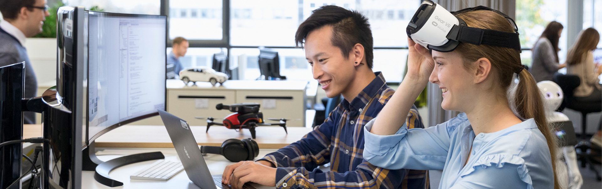 Two Dual Students working together in a modern working space with a VR glasses.