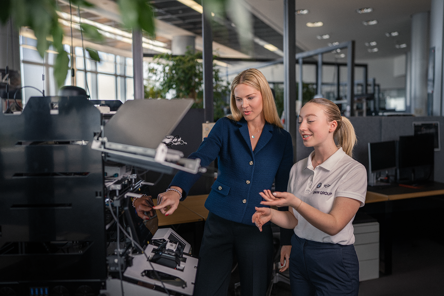 A student and their mentor in front of a computer.
