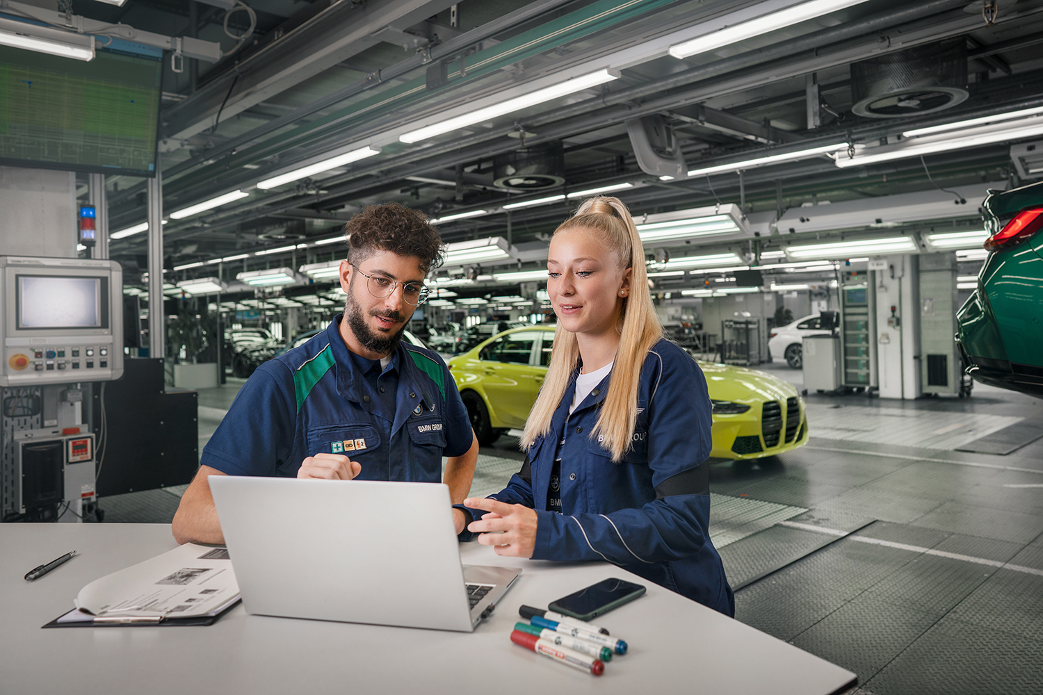 Two Dual Students for mechanical engineering working together in a workshop at the BMW Group.