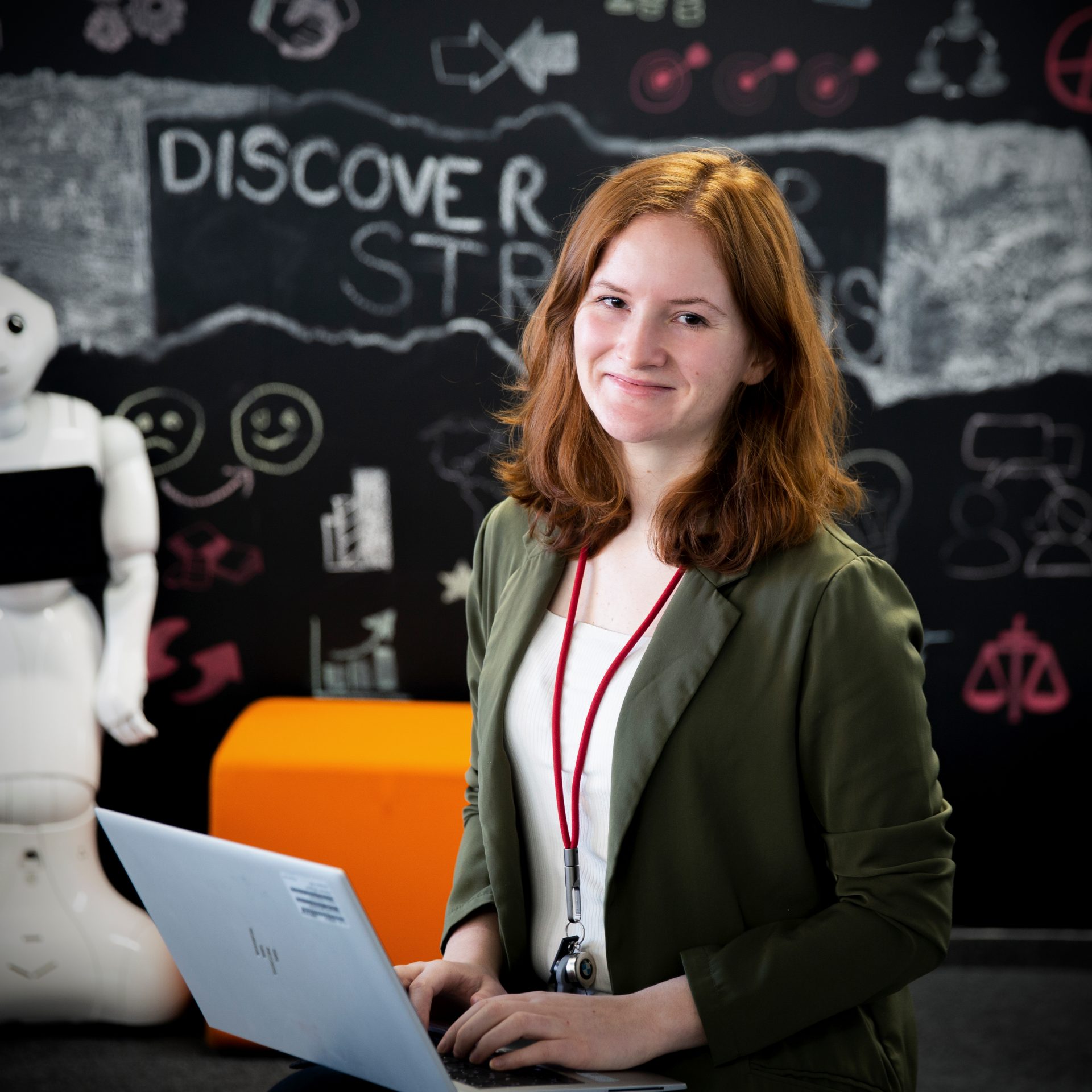 The trainer for IT apprenticeships working on her Computer smiles at the camera.
