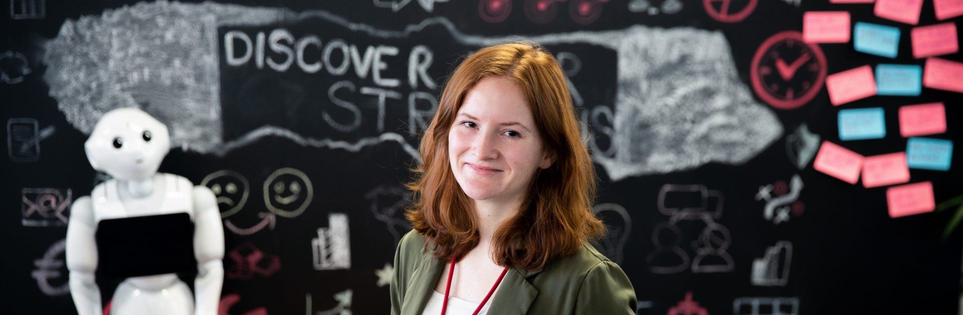 The trainer for IT apprenticeships smiles at the camera while working on her computer.
