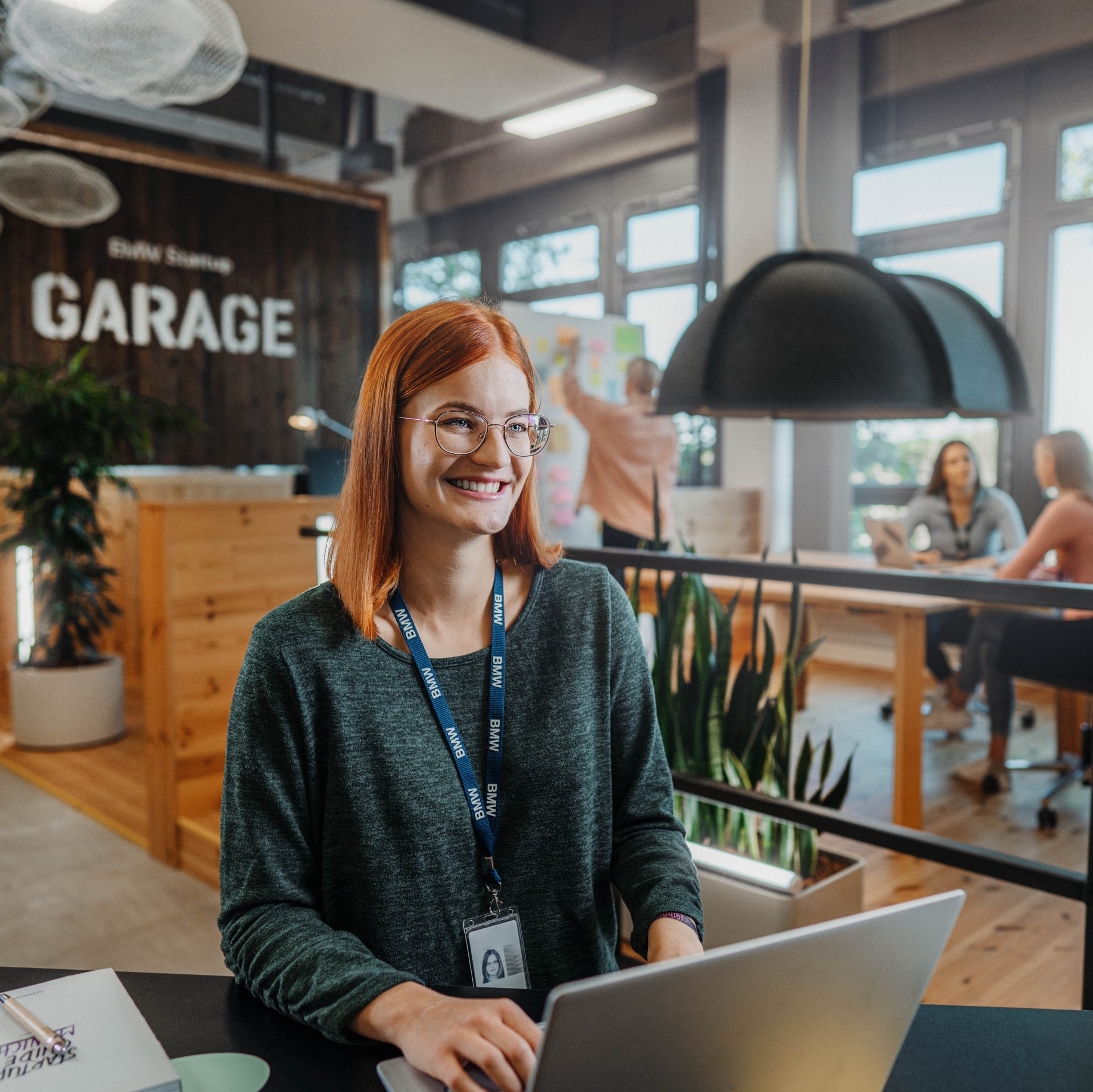 A young dual student working in a modern office environment at the BMW Group.