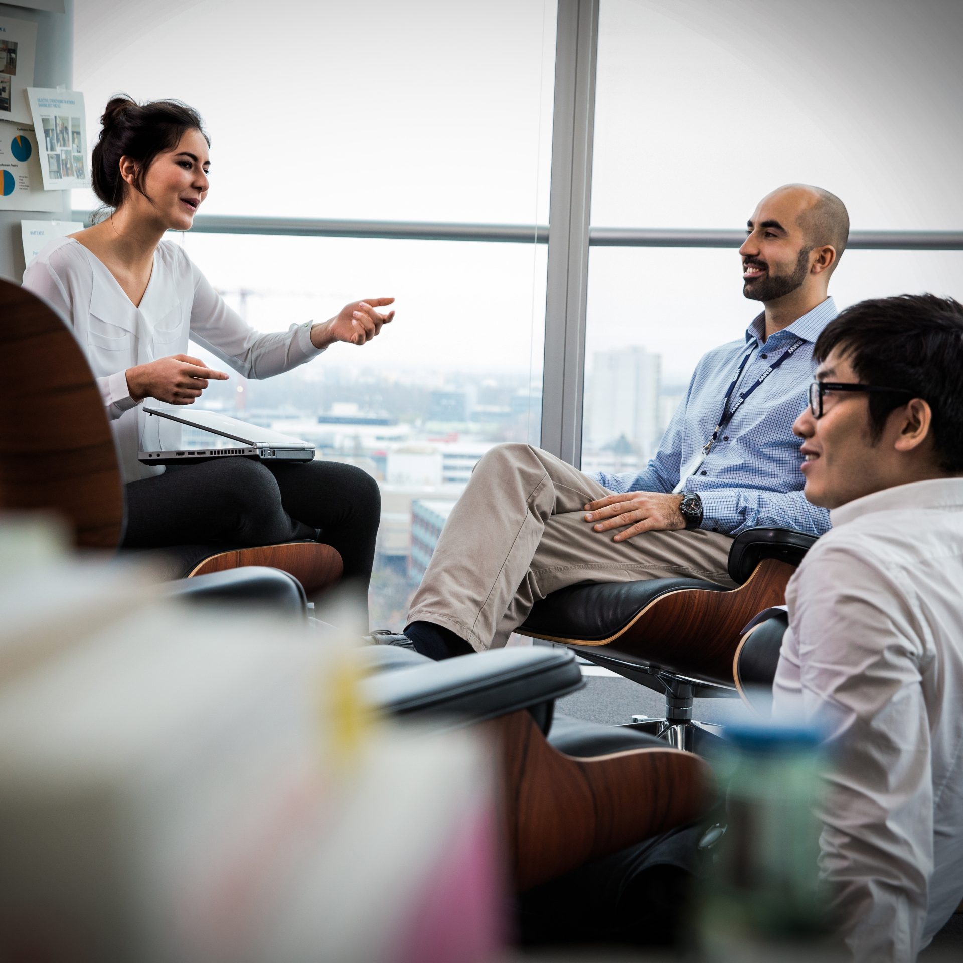 Three employees at the BMW Group are having a conversation.