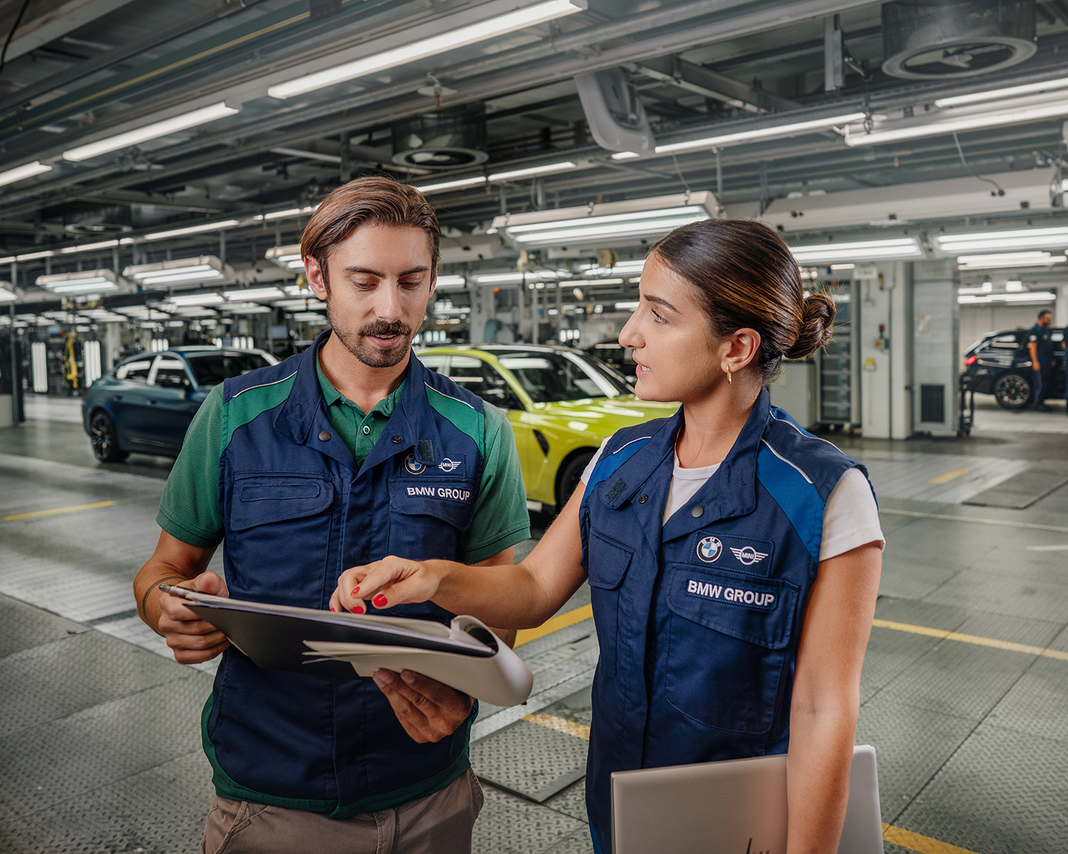 Three employees at the BMW Group are having a conversation.