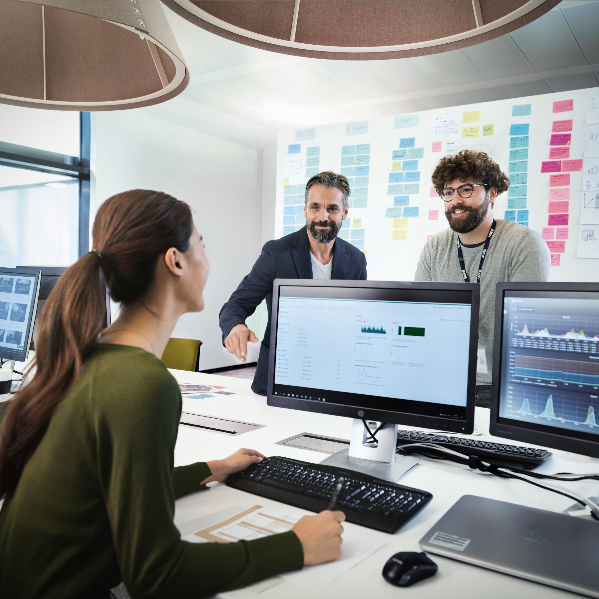 Three BMW Group employees in a conversation.