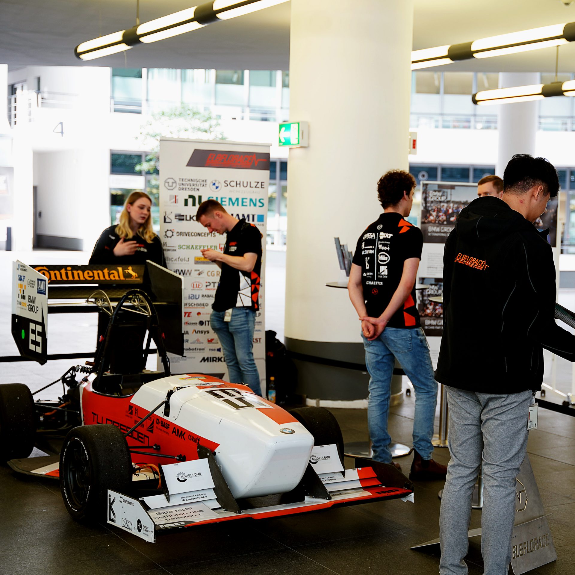 People looking at the different race cars at the FIZ Event.