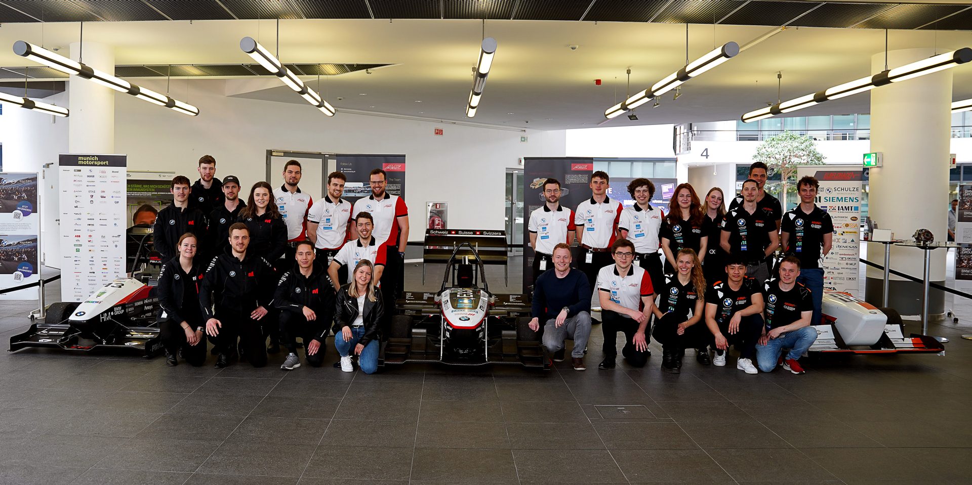The racing team standing around their race car.