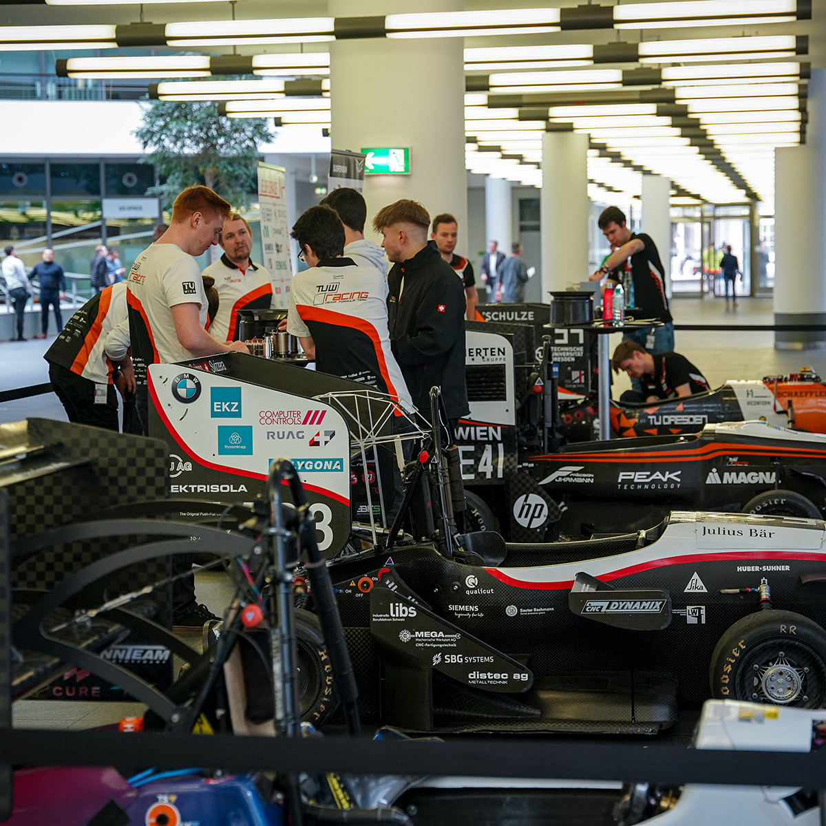 Team member work on a race car in a workshop.