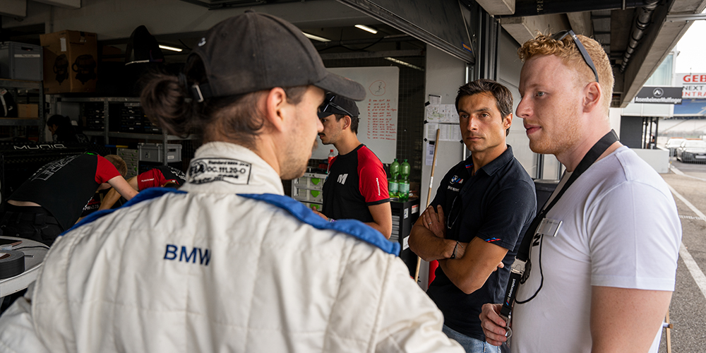 Racing team standing together having a conversation.