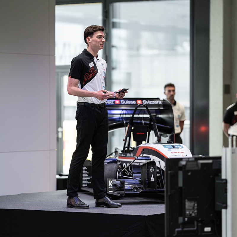 A student is presenting the race car on stage.