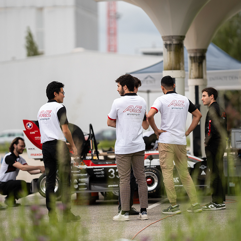 Four students are taking a look at a race car.