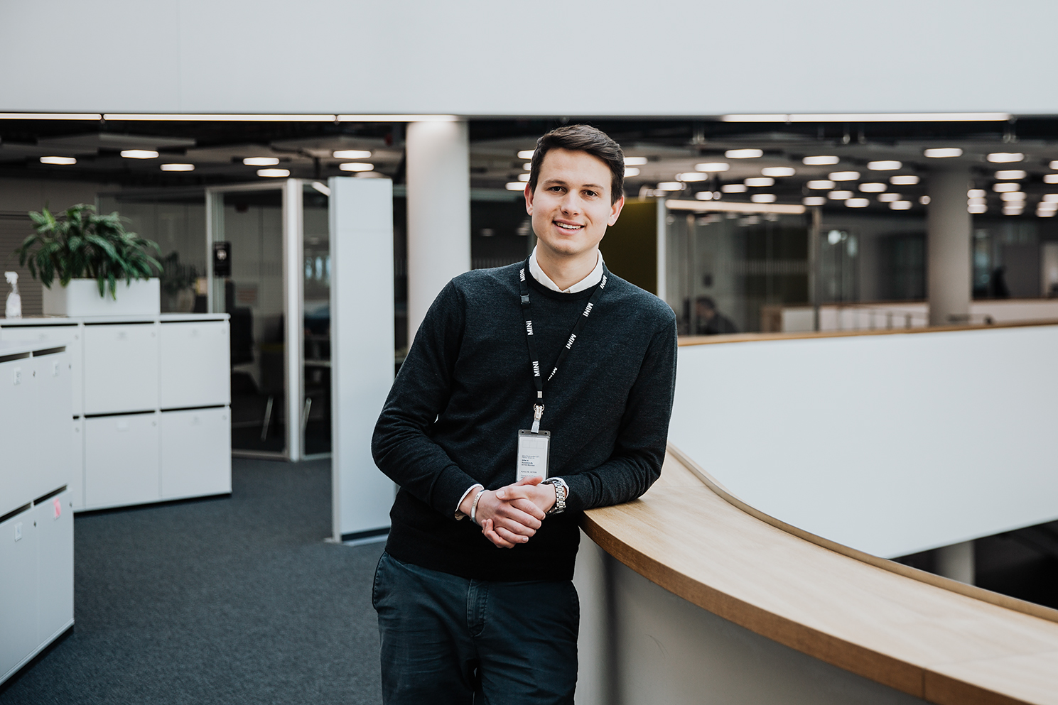 A trainee in the acceleration programme standing in a modern office environment at the BMW Group.