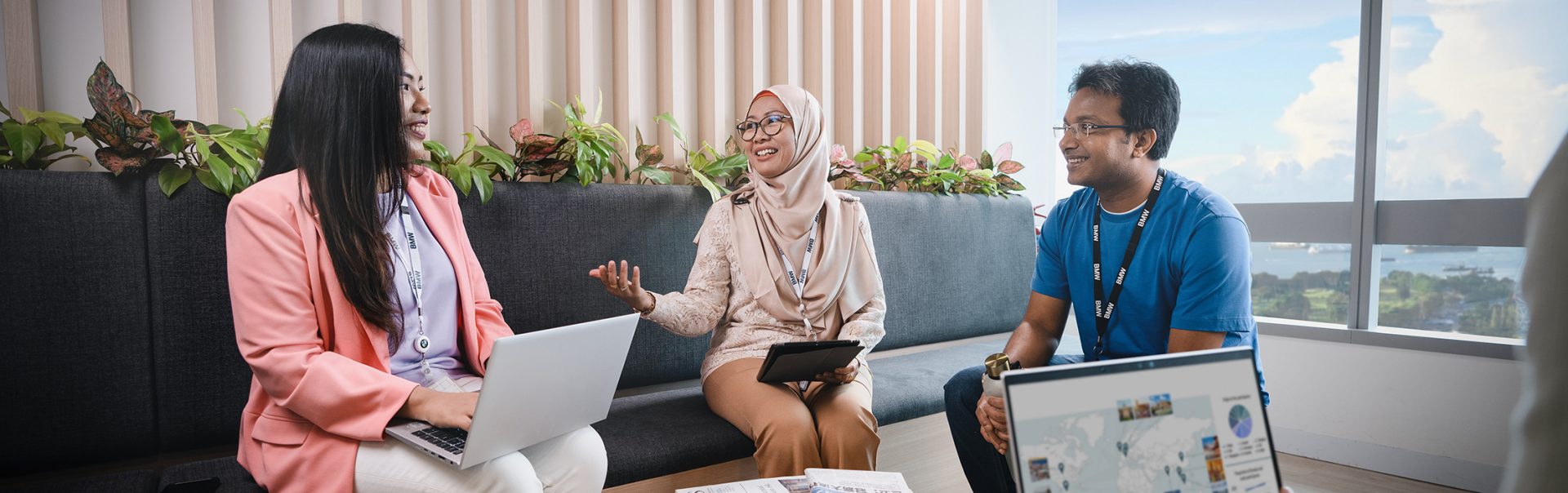 Three trainees having a conversation in an office environment