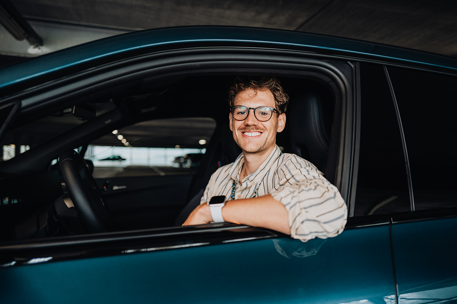 PhD student Phillip looks out the window of a BMW iX.