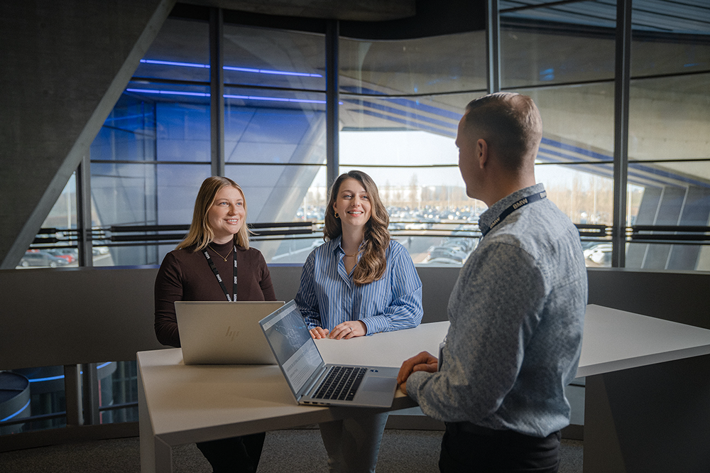 Three colleagues have a conversation in the meeting room.