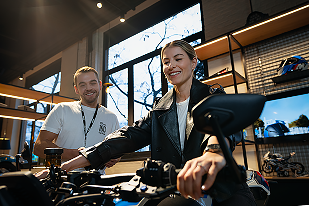 A woman sits on a motorcycle at her workstation.