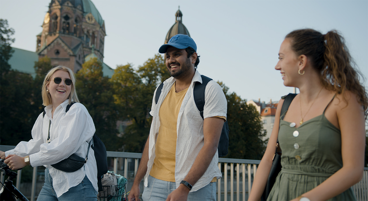 Das Foto zeigt drei lachende BMW Mitarbeiter bei einem Spaziergang draußen.