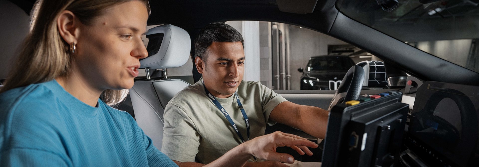 A student and his supervisor work on a laptop in the vehicle cockpit.