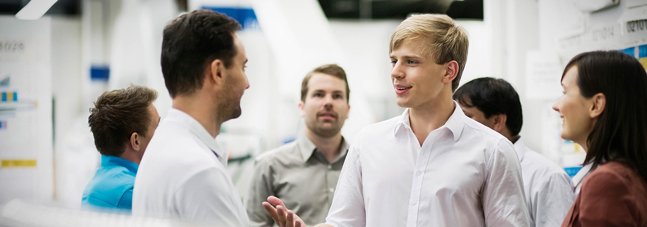 Two apprentices at an BMW Group event talking.