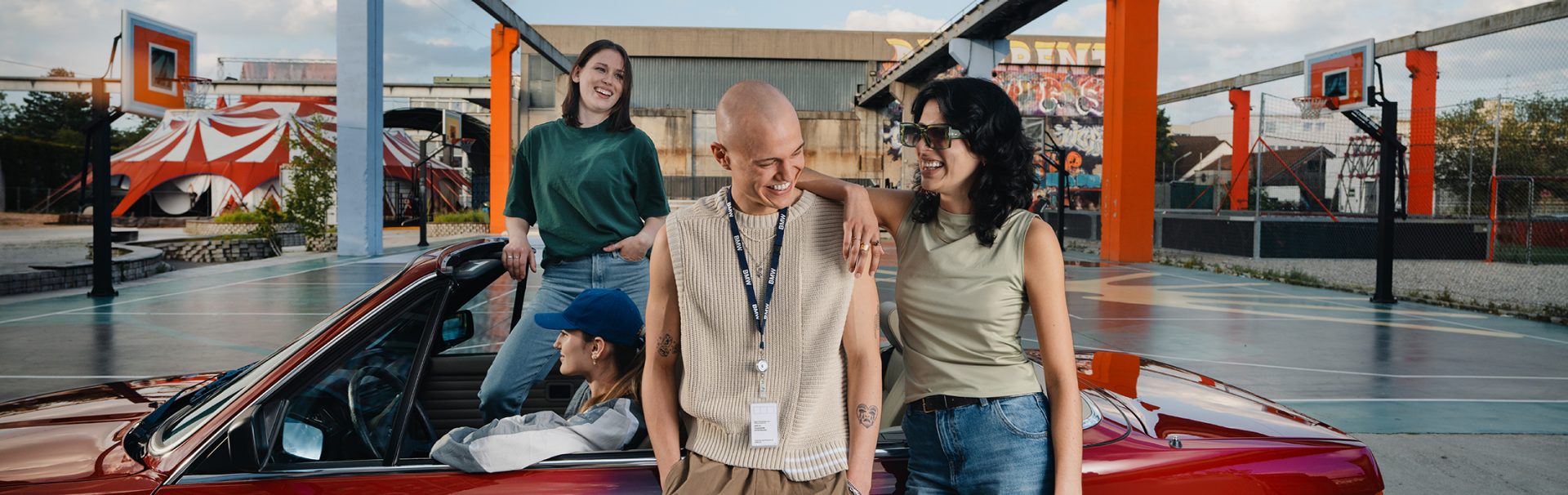 Four interns with a BMW E30 at an urban basketball court.