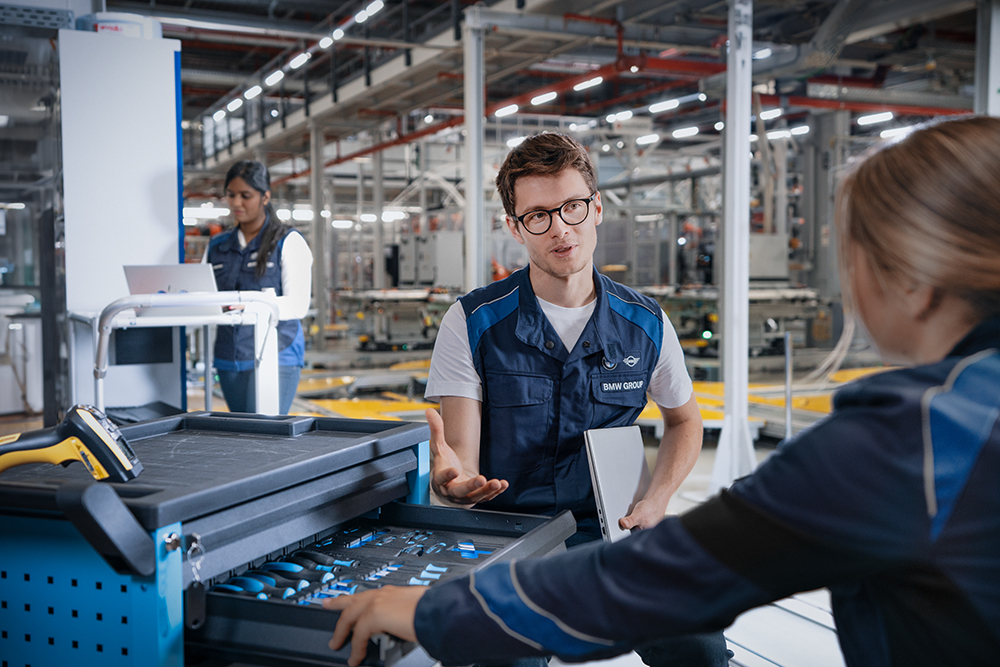 A BMW Group working student in production is having a chat with a colleague.