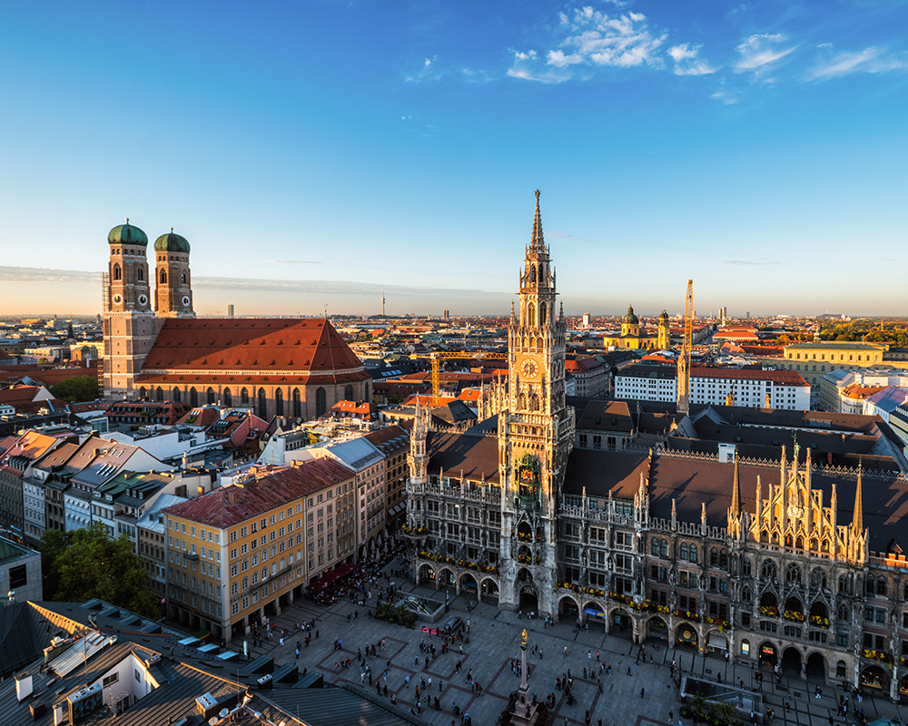 The image shows the Frauenkirche in Munich and the surrounding city.