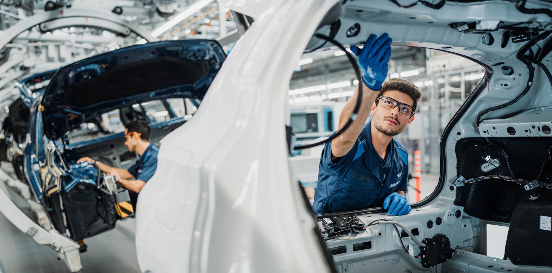 The picture shows two men working in production at BMW.