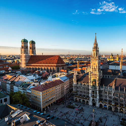 The image shows the Frauenkirche in Munich and the surrounding city.