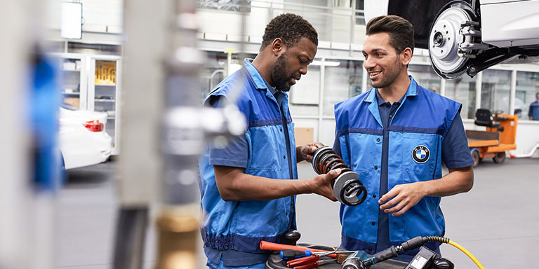 The picture represents the job culture by showing two BMW production employees.