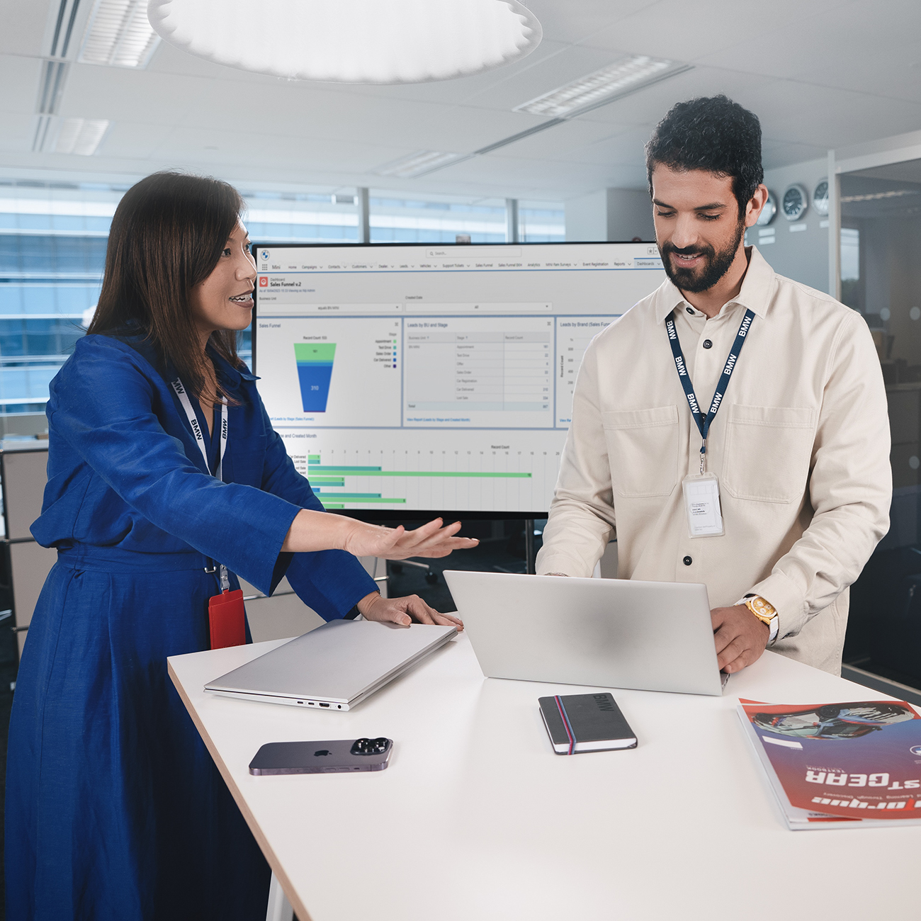 The image shows two colleagues having a conversation.