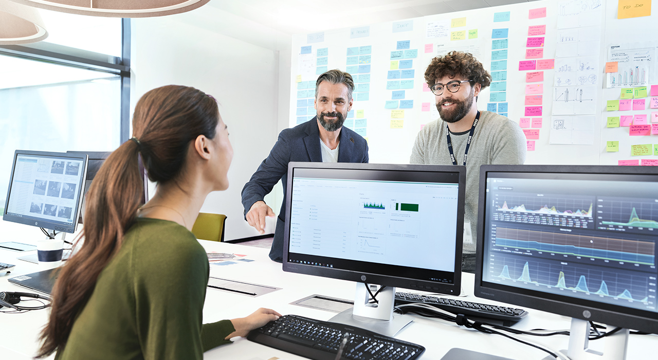 Three BMW professionals, a female one and two male ones, are meeting in an office to discuss a new project.    
