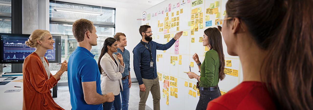 The image shows a group meeting at the BMW Group.