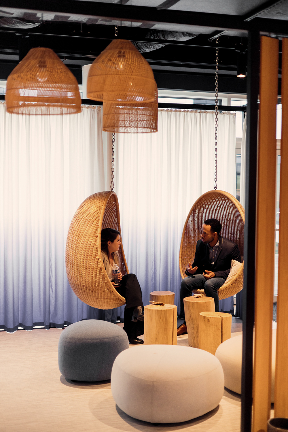 Deux collègues discutent assis sur deux fauteuils à bascule.