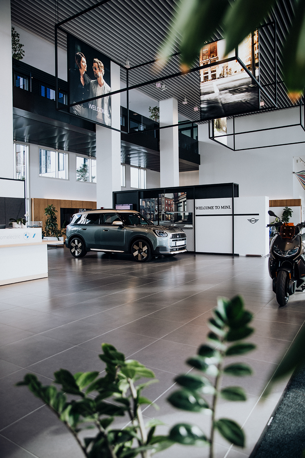 Photo de l'intérieur du hall d'entrée du campus du groupe BMW en France, où est garée une MINI Countryman.