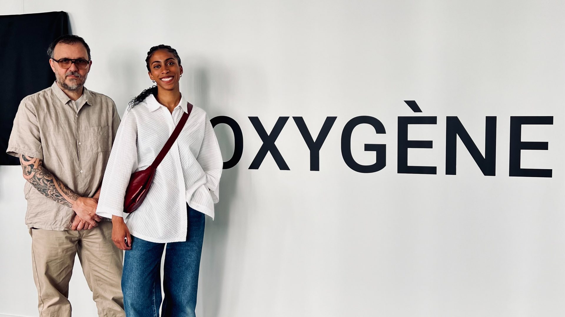 Yama Ndiaye and Fabrice Laroche standing before a wall with the words "Oxygène" on it