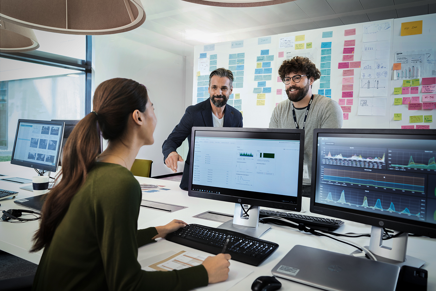 Three colleagues working in data science are having a chat at their desk
