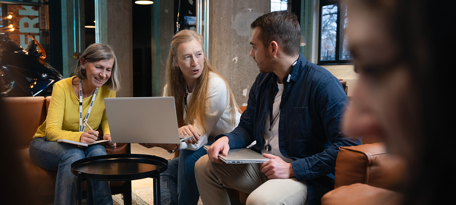 Trois collègues, dont deux plus âgés que l'autre, travaillant ensemble dans un bureau.
