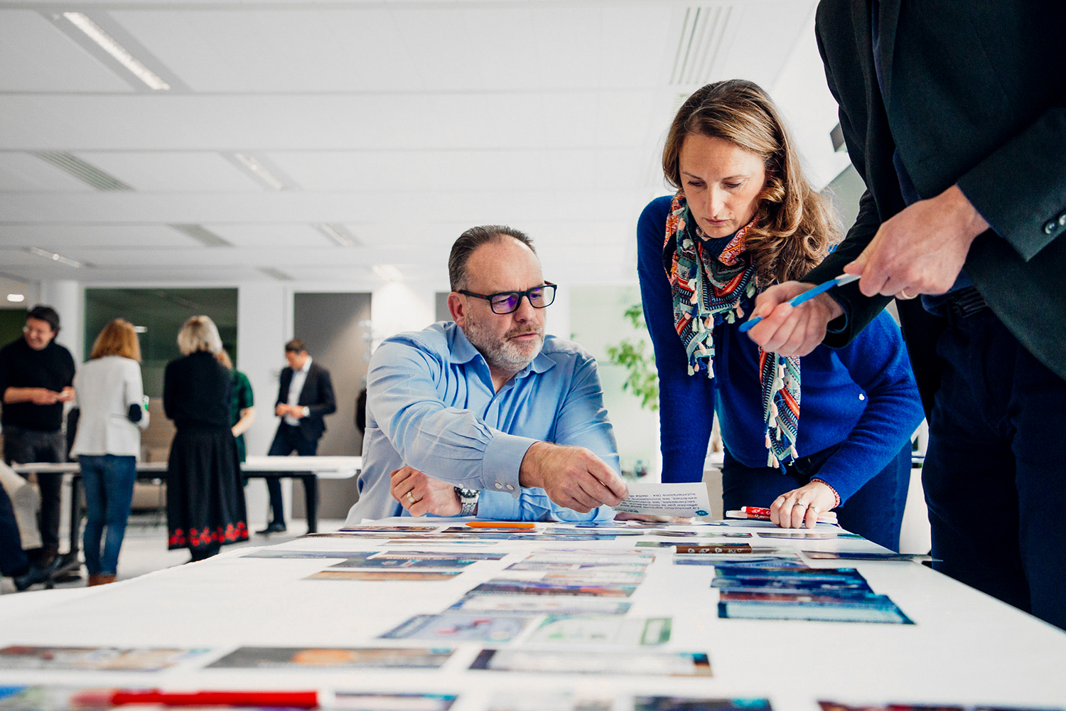 Trois collègues travaillant de manière agile lors d'un atelier, avec des crayons et des cartes