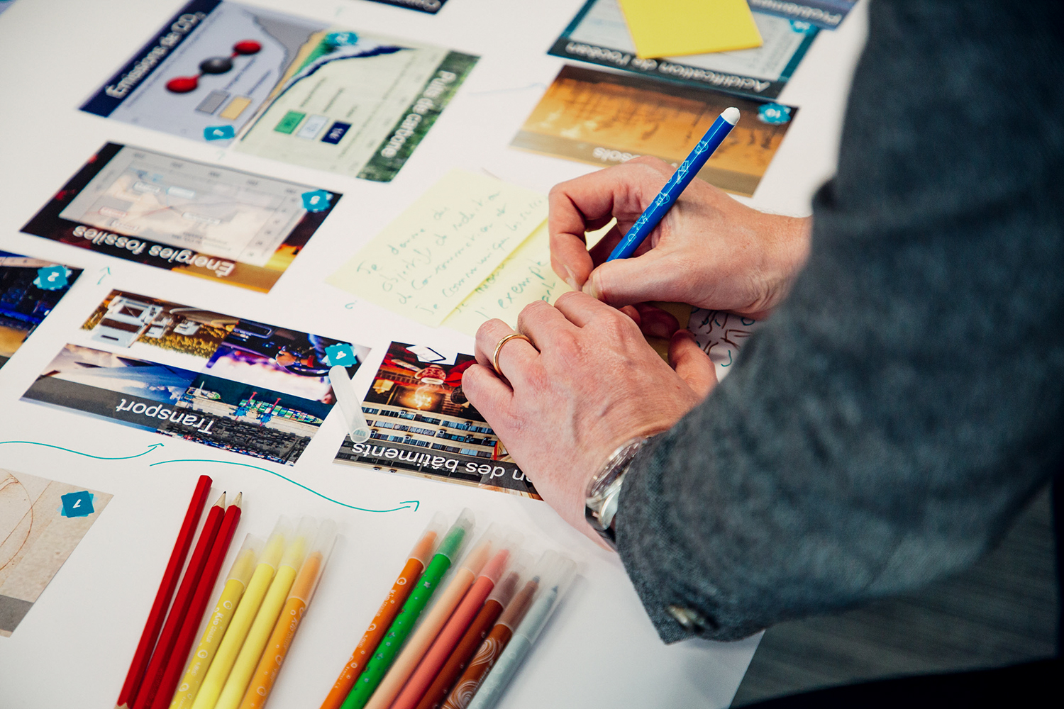 Gros plan sur les mains d'une personne écrivant sur des cartes avec un stylo