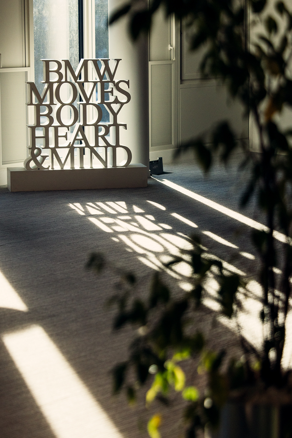 Panneau « BMW moves body, heart & mind » dans un bureau ensoleillé