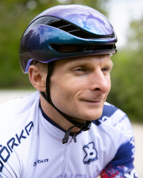 Portrait de Nicolas portant un casque alors qu'il roule à vélo de course