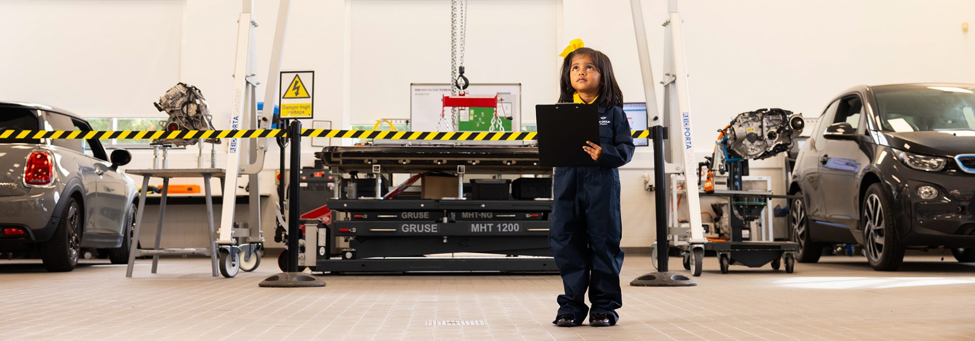 School student standing in a vehicle workshop environment at BMW Group
