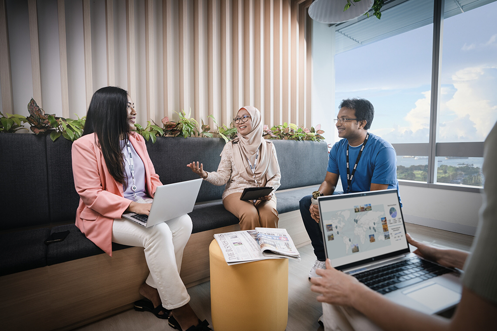 Graduate employees collaborating and discussing ideas in a contemporary office space.